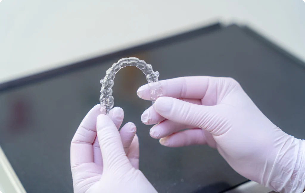 Mains gantées présentant un aligneur transparent