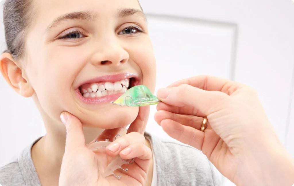 Fillette souriante et plaque palatine verte