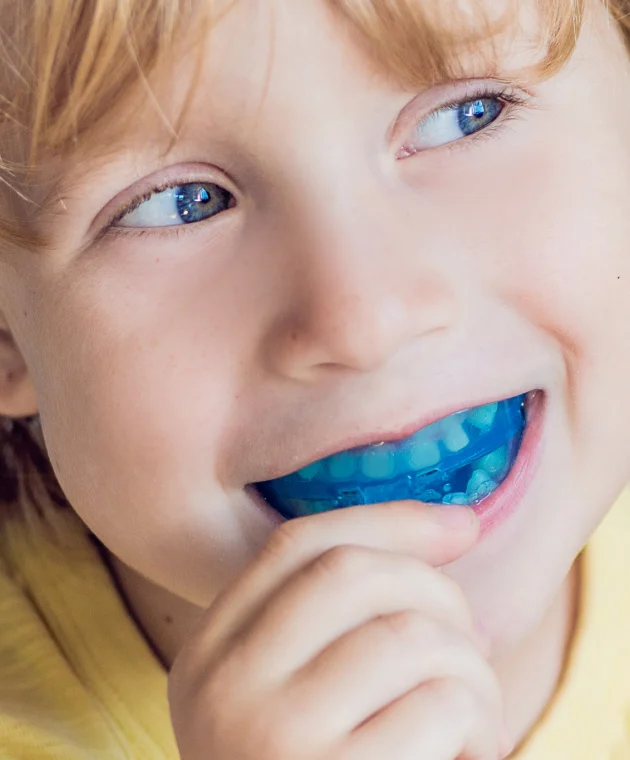 Garçon portant un éducateur fonctionnel bleu en bouche