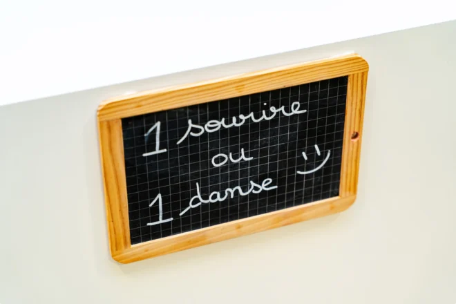 Ardoise « 1 sourire ou 1 danse » au mur du cabinet