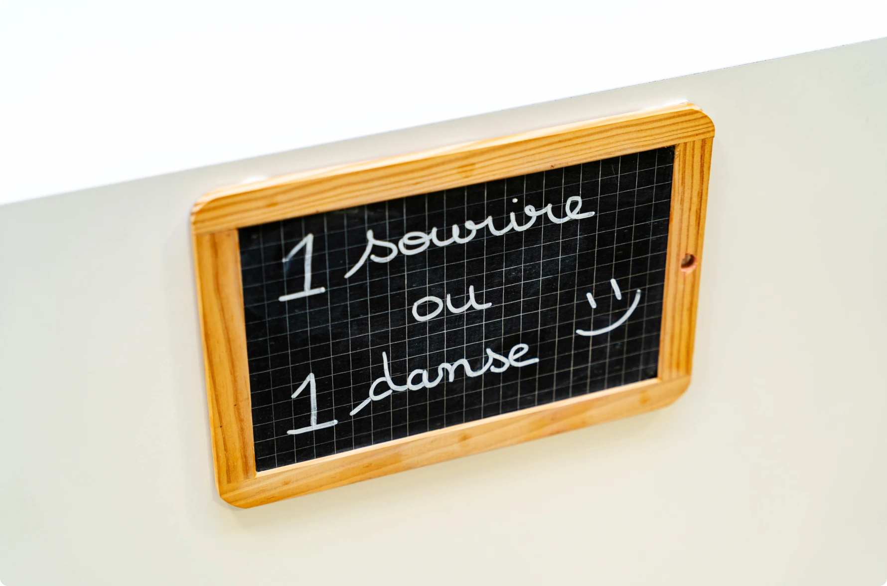 Ardoise « 1 sourire ou 1 danse » au mur du cabinet