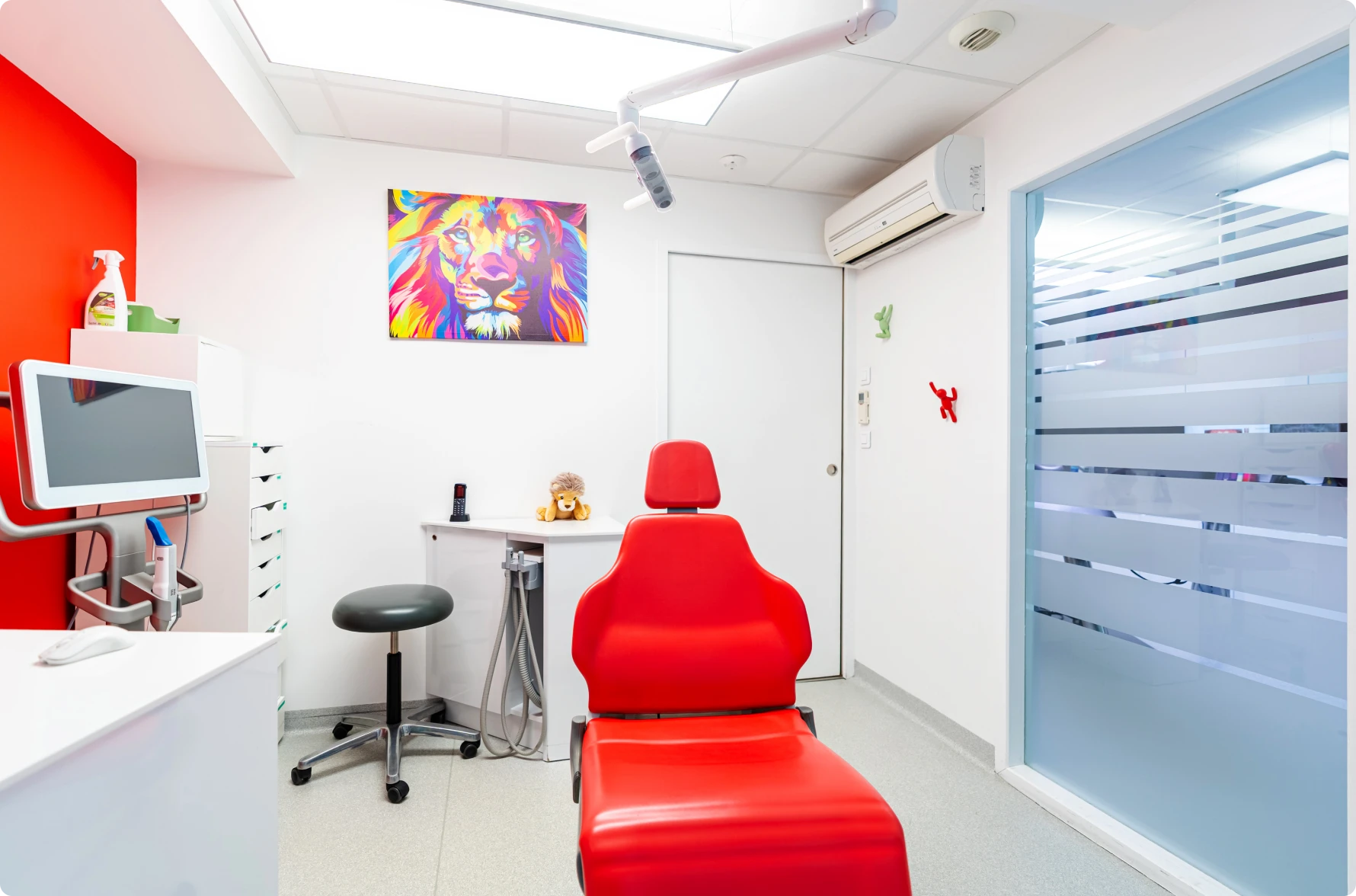 Fauteuil rouge et tableau de lion en salle de soins
