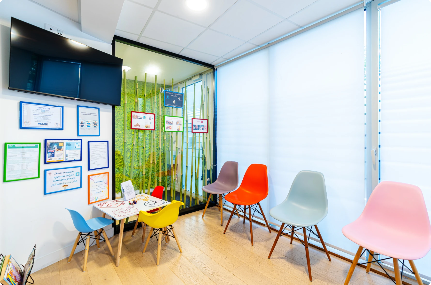 Salle d’attente aux chaises colorées et dessins d’enfants
