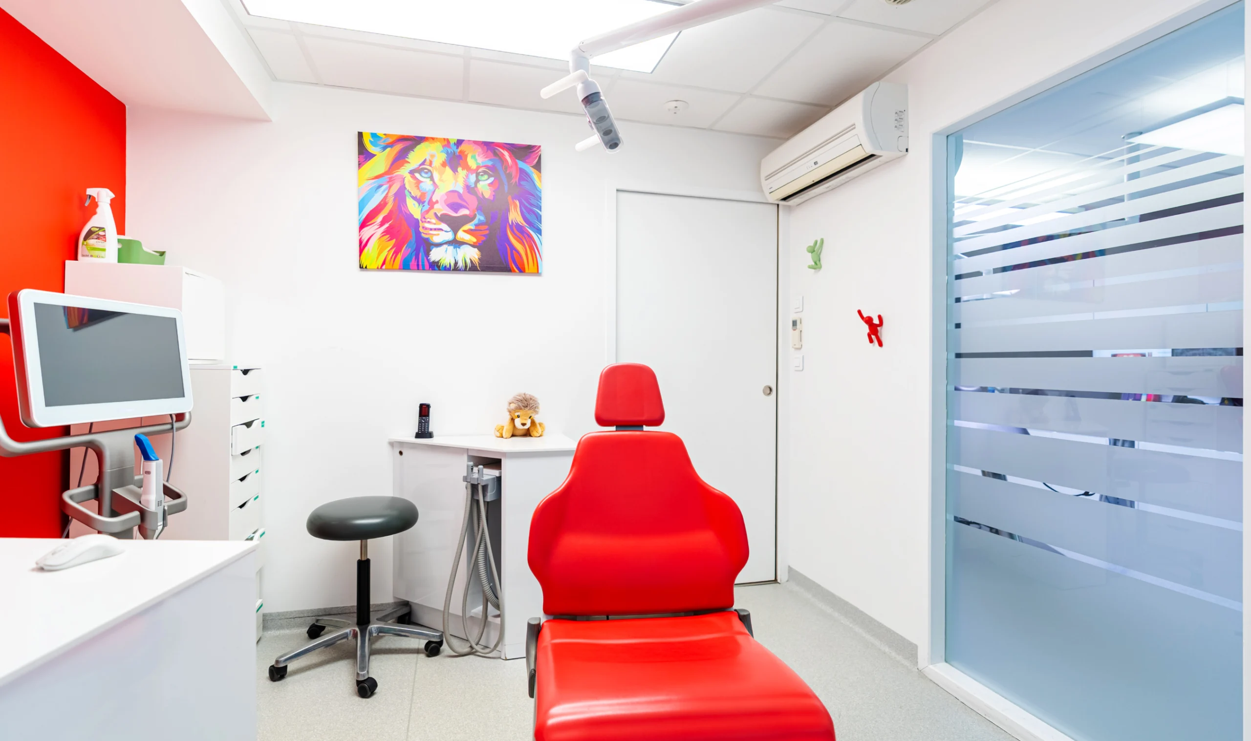 Salle de soins au fauteuil rouge et tableau de lion